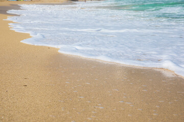  Rolling a wave with foam on a sandy shore