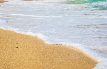 Rolling a wave with foam on a sandy shore