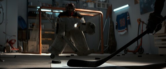 Kid boys friends or brothers practicing hockey shots inside a covered garage. Shot with 2x anamorphic lens
