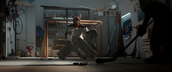 Kid boys friends or brothers practicing hockey shots inside a covered garage. Shot with 2x anamorphic lens