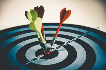 Close up shot of the dart arrow hit on bulleyes of dartboard to represent that the business reached...