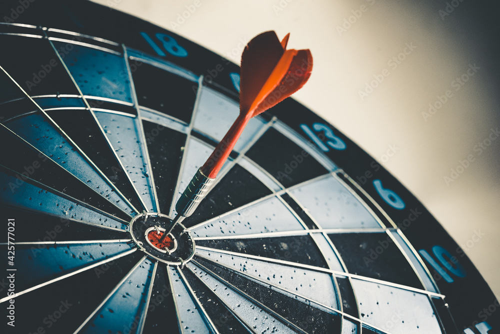 Aufkleber close up shot of the dart arrow hit on bulleyes of dartboard to represent that the business reached 
