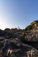  shot of a white Caucasian man walking on the rocks