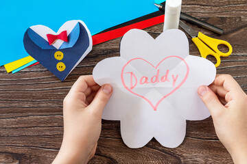 Greeting card for on Father's Day heart in tuxedo with Daddy lettering on wooden table. Handmade. Childrens creativity project, crafts, crafts for kids.