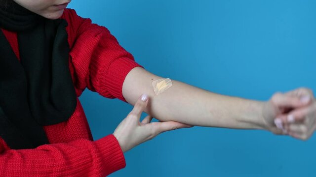 Young woman shows a adhesive plaster on arm after blood donation or blood testing. High quality 4k footage