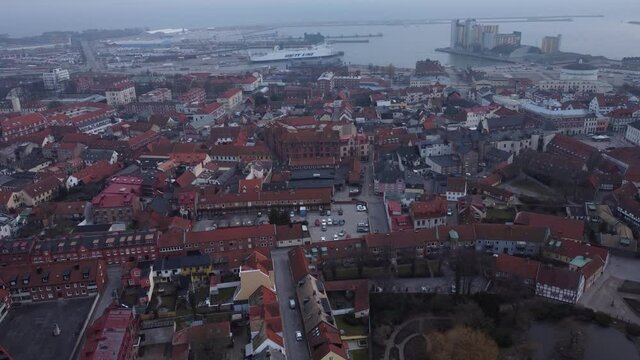 High drone flight over Ystad - Aerial view of a city with a view of a church and the sea