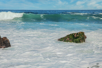 Beautiful seascape of the Pacific coast in California, waves, rocks, sky, sun. Concept, perfect postcard and guide.