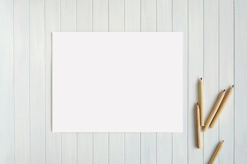 Blank horizontal paper sheet and pencils on wooden background, US letter size coloring page, stationery mockup, back to school, education, drawing concept.