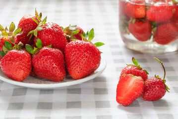 Ripe strawberries in a white plate on the table