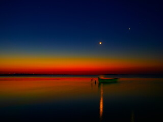 Fototapeta na wymiar beautiful view of old fishing boat silhouette before sunrise