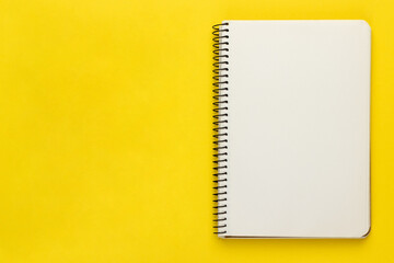 Open spiral notebook, notepad, sketch book with blank empty white sheets and binder on bright...