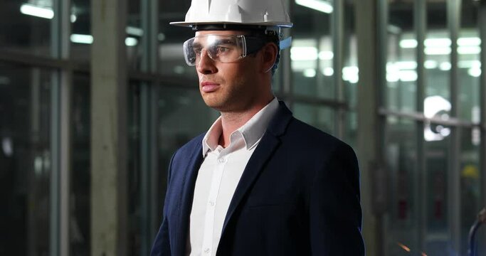 Portrait confident engineering man in safety hardhat helmet at lathe industrial manufacturing factory