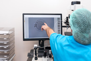 Embryologists perform test with human eggs. Doctor working on manipulator fertilizing human egg in...