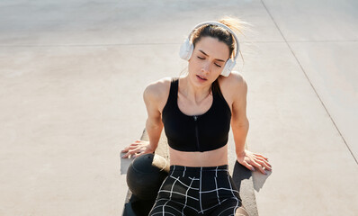 Trendy fit sports woman taking break from exercising with eyes closed