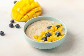 Oatmeal porridge with mango and blueberries. Healthy breakfast