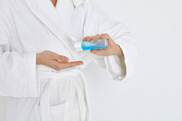 female hands hold a cotton swab and tonic to remove makeup.