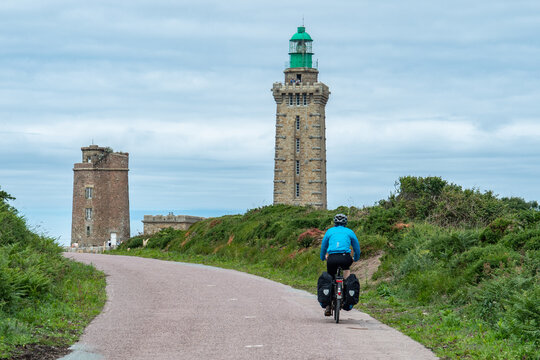 Cycling towards the lighthouse of Cap Frehel on Eurovelo 4, Bretagne, France.
