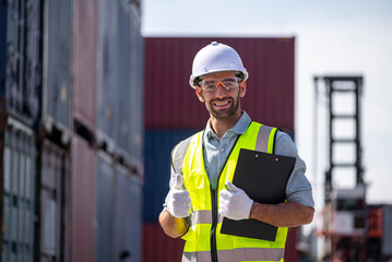 happy inspector working working with checking list of shipping container with smile service in commercial transport port