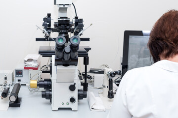 Doctor or scientist working with computer and microscope in biotech lab. Equipment in laboratory of Fertilization, IVF.