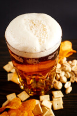 lager beer and snacks on wooden table. Nuts, chips, crackers. Craft beer. Beerboard.