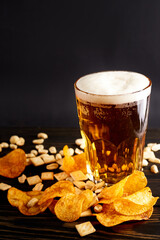 lager beer and snacks on wooden table. Nuts, chips, crackers. Craft beer. Beerboard.