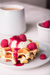 Freshly baked waffles with raspberry and ice cream on a plate