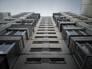 Bottom-up view of an old dirty gloomy residential multi-storey prefabricated concrete house in the...