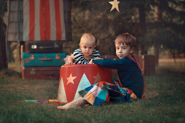 Portrait of cute baby girl and her older brother dressed in vintage circus style. Image with...