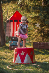 Cute little funny girl dressed like a circus actress is on the circus pedestal. Image with selective focus and toning © Smolina