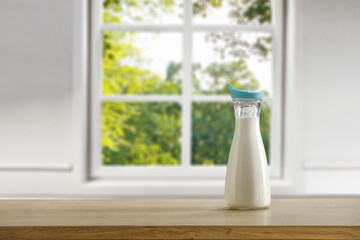 Fresh cold milk in glass and window in home interior 