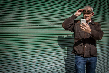 Fototapeta na wymiar man with sunglasses using mobile phone in the city