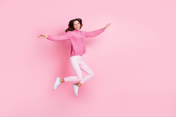 Full size profile photo of optimistic cool brunette lady jump wear pink sweater trousers sneakers isolated on pink background