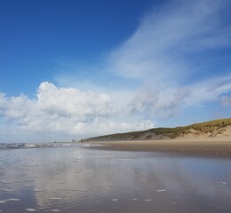 Summer skies reflected in the moist sands of Texel dunes.