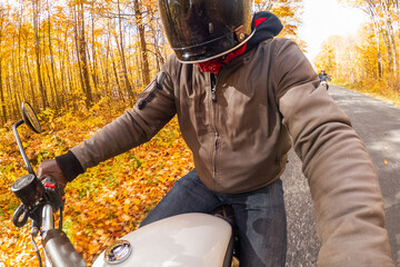 Young man riding his motorcycle in the fall with a GoPro