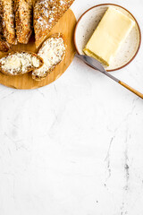 Slice of bread with butter on white background top view space for text