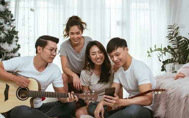 Asian people having party, playing guitar at home