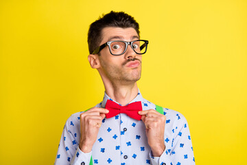 Photo of young handsome arrogant man confident fix correct bowtie prepare date isolated over yellow...