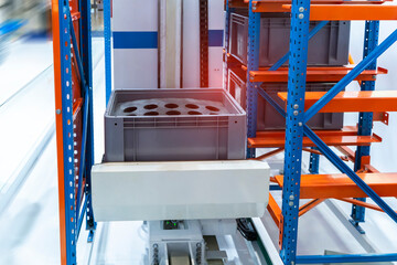 plastic boxes in the cells of the automated warehouse. Metal construction warehouse shelving