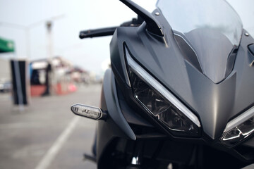 closeup headlight front view of motorcycle bigbike in showroom with soft-focus and over light in...