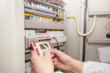 The electrician engineer programs the electrical control circuitry of the electrical system. Smart...