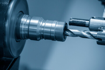 The  CNC lathe machine drilling  the pipe connector parts. The hi-technology metal working processing by CNC turning machine .