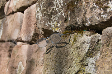 Eine von Spaziergängern in einer Mauer zurückgelassene Brille
