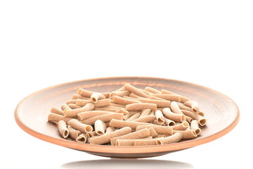 Dark brown, uncooked, organic rye paste on a clay platter, close-up, isolated on white.