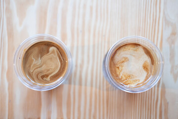 Two cup of dirty coffee on wooden table background.