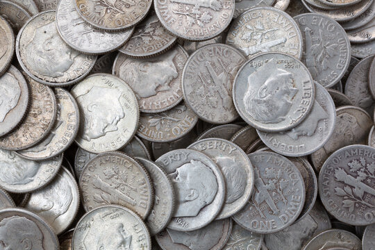 Very close view of old silver dimes illuminated with natural light.