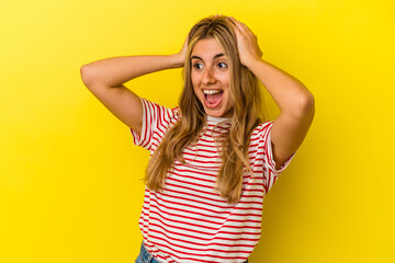 Fototapeta premium Young blonde caucasian woman isolated on yellow background screaming, very excited, passionate, satisfied with something.