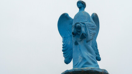 Low angle view of a transparent statue of blue angel. Religion or LGBTQ symbol. Transgender concept.