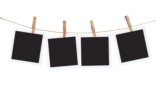Four blank instant photo frames hanging on a rope, isolated on white background