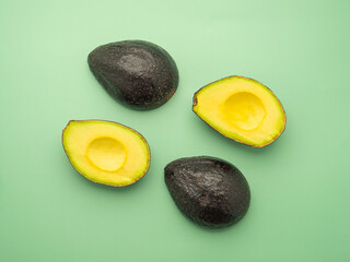 Top view of fresh avocado half on the green background. Organic fruit. Space for text. Concept of...