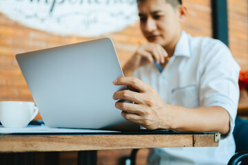 Young businessman working laptop in coffee shop. Business and freelance job concept.